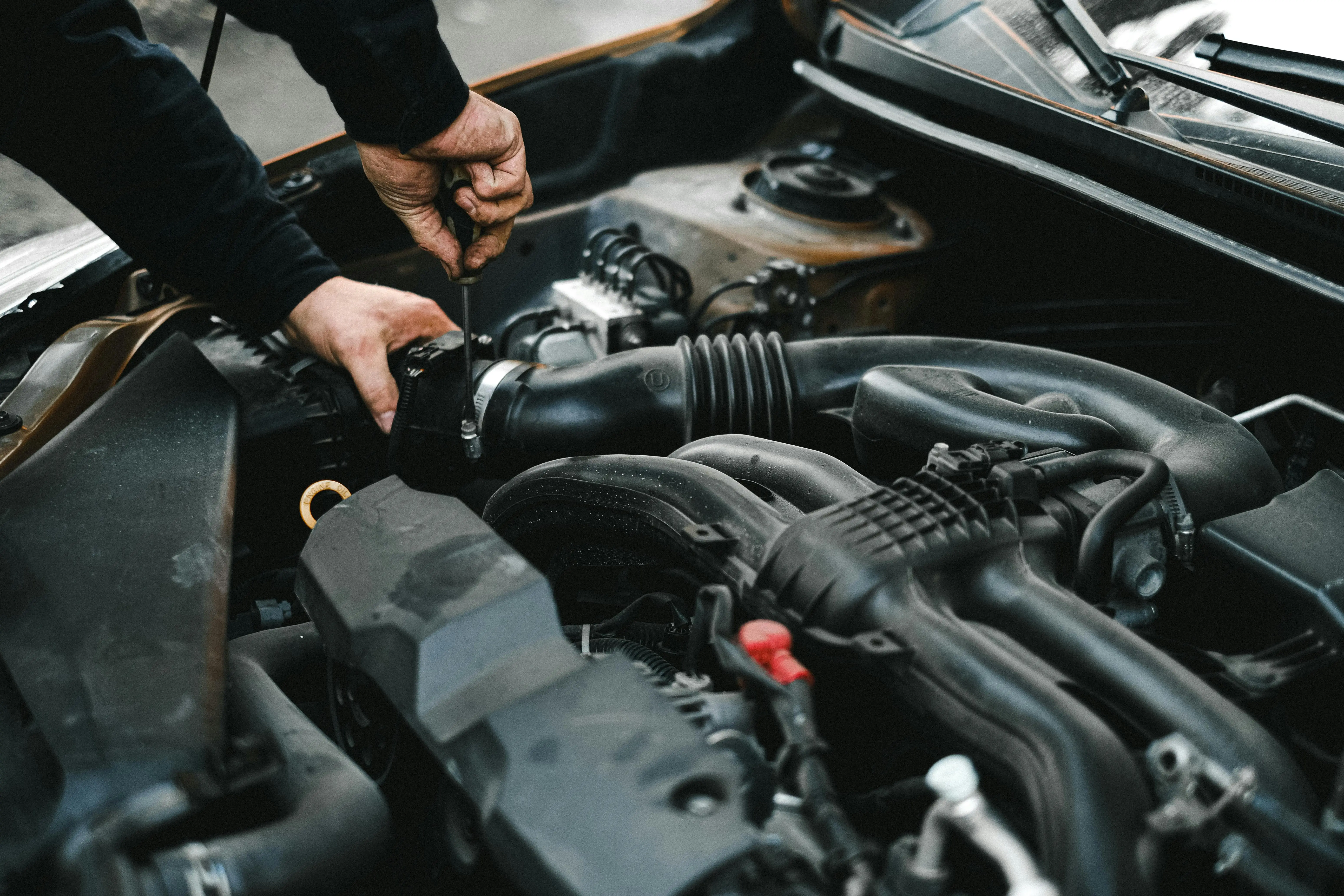 A technician working on a vehicle near the parts counter at a dealership